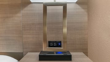A modern, minimalist room with a central, metallic, rectangular object that appears to be a piece of furniture or an art installation.