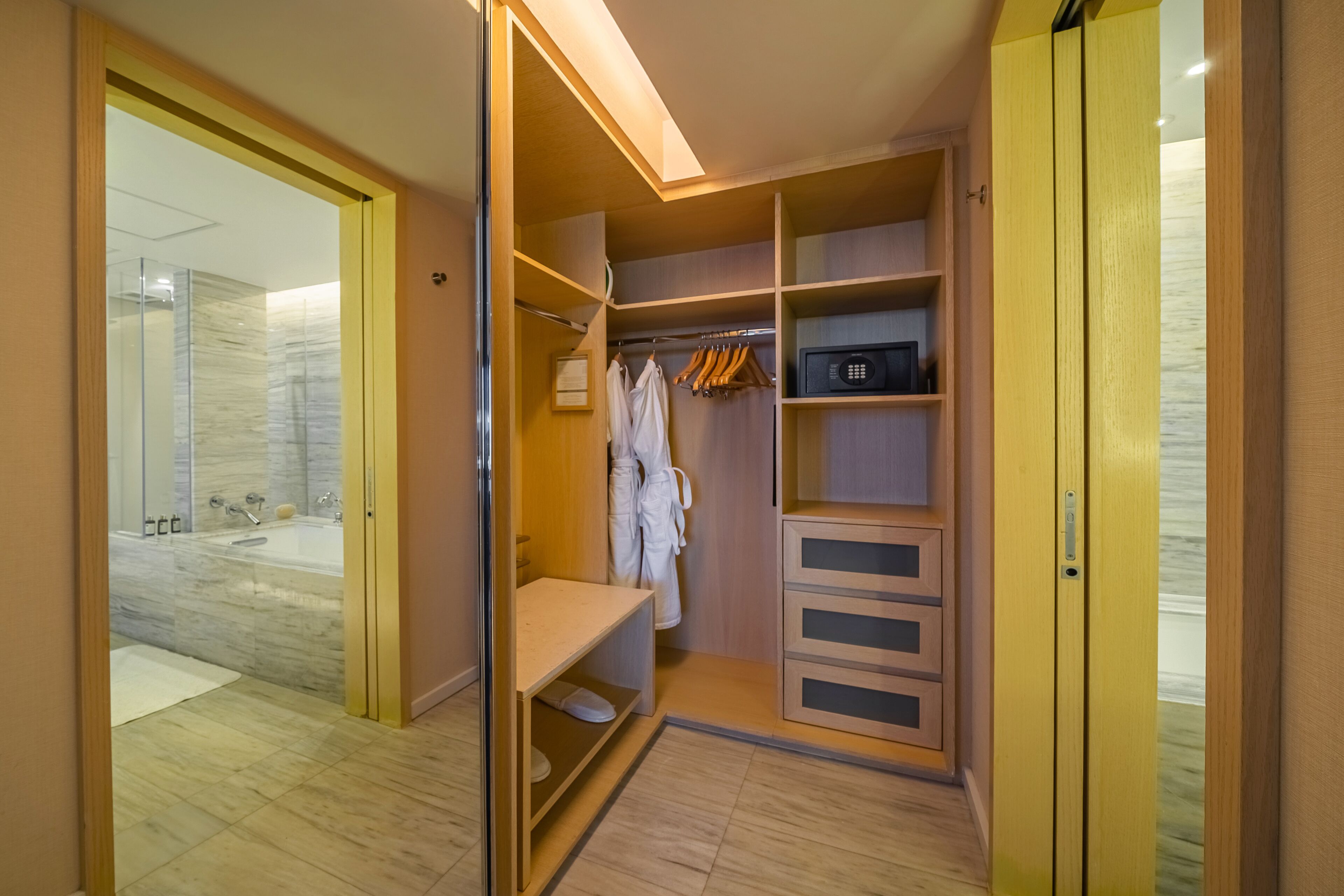 Un dressing avec des étagères en bois, un porte-manteau et un four à micro-ondes.