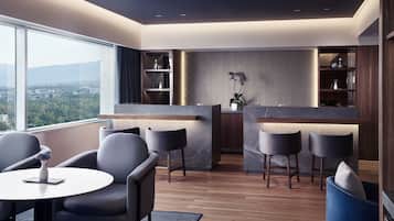 Una sala de estar moderna con zona de cocina, ventanas amplias y vista a la ciudad.