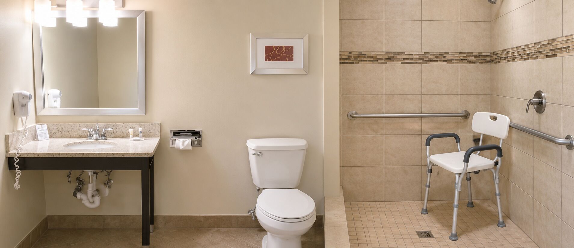 A bathroom with a sink, mirror, toilet, and shower area with a handrail.
