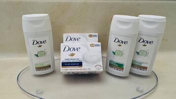 Dove body lotion, Dove cream beauty bar, and Dove shampoo on a bathroom counter.