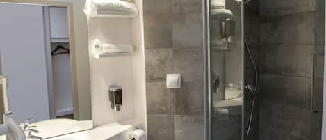 Un baño moderno con ducha envuelta en vidrio, un lavabo blanco y un inodoro.