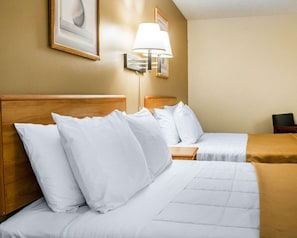 A hotel room with two beds, a nightstand, a lamp, and a framed picture on the wall. - Econo Lodge Elkhart North (Elkhart)