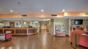 A hotel lobby with a reception desk, seating area, and a fireplace.