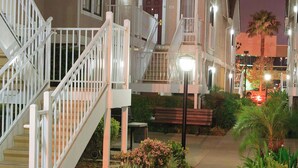 A residential building with a central staircase, a small garden area with flowers, and a well-lit entrance. - Residence Inn by Marriott Anaheim Placentia Fullerton (Placentia)