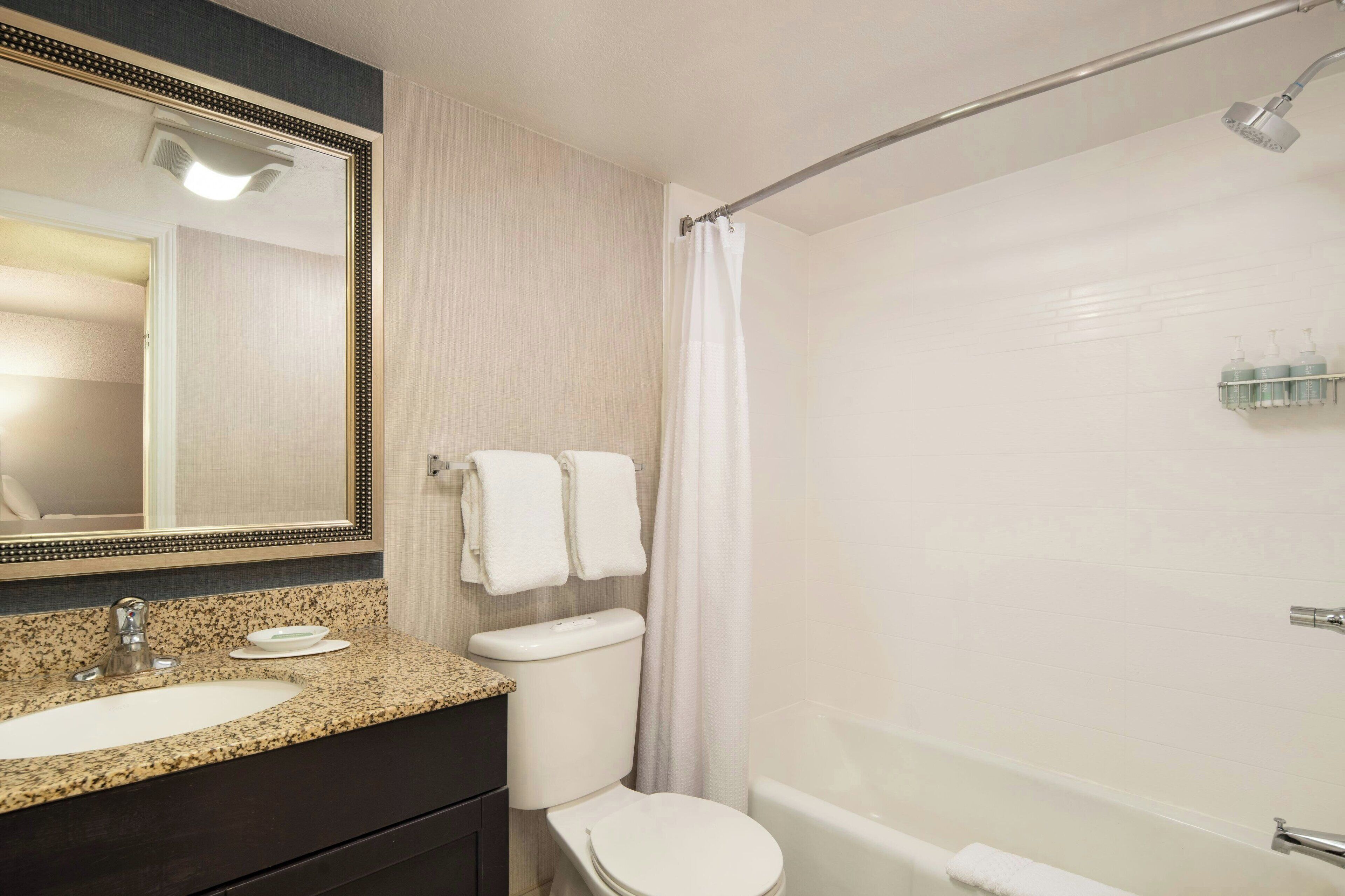 A bathroom with a sink, toilet, and bathtub.