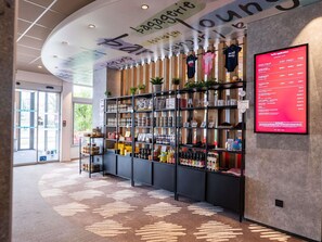 A modern interior with a curved ceiling, a reception desk, and a wall-mounted menu board. - ibis Dijon Gare (Dijon)
