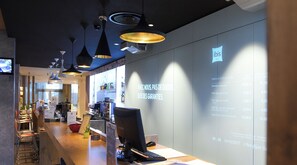 A modern hotel lobby with a reception desk, computer, and seating area. - ibis Dijon Gare (Dijon)