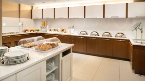 Una cocina moderna con un bufé, que incluye diferentes opciones de comida y una estación de café.