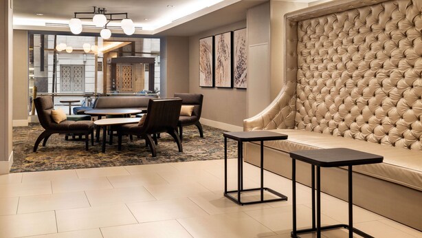 Un moderno vestíbulo de hotel con comedor, un sofá y una gran pared tapizada.