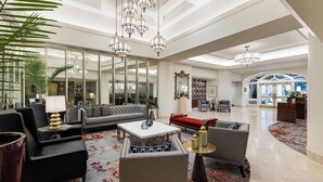 Un vestíbulo amplio con una decoración moderna, que incluye sofás, una mesa de centro y un espejo grande.