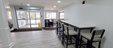 A modern interior with a bar area, seating, and a sliding glass door entrance.