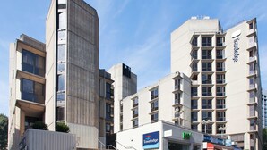 A Travelodge hotel with a modern design, featuring a staircase leading to the entrance, and a visible signboard. - Travelodge London Covent Garden (London)
