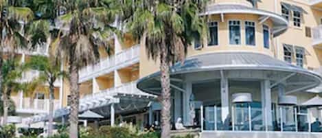 A hotel with a pool area, palm trees, and a building with multiple balconies.