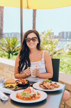 Guests can dine al fresco with a view of the surrounding greenery and water.