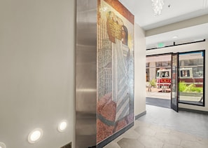 Un interior moderno con una pared de mosaicos, una puerta de cristal y un colgador de techo.