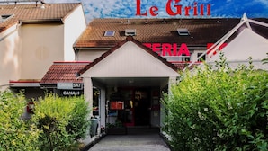 A restaurant named "Le Grill" with a red sign, a covered entrance, and a visible satellite dish.