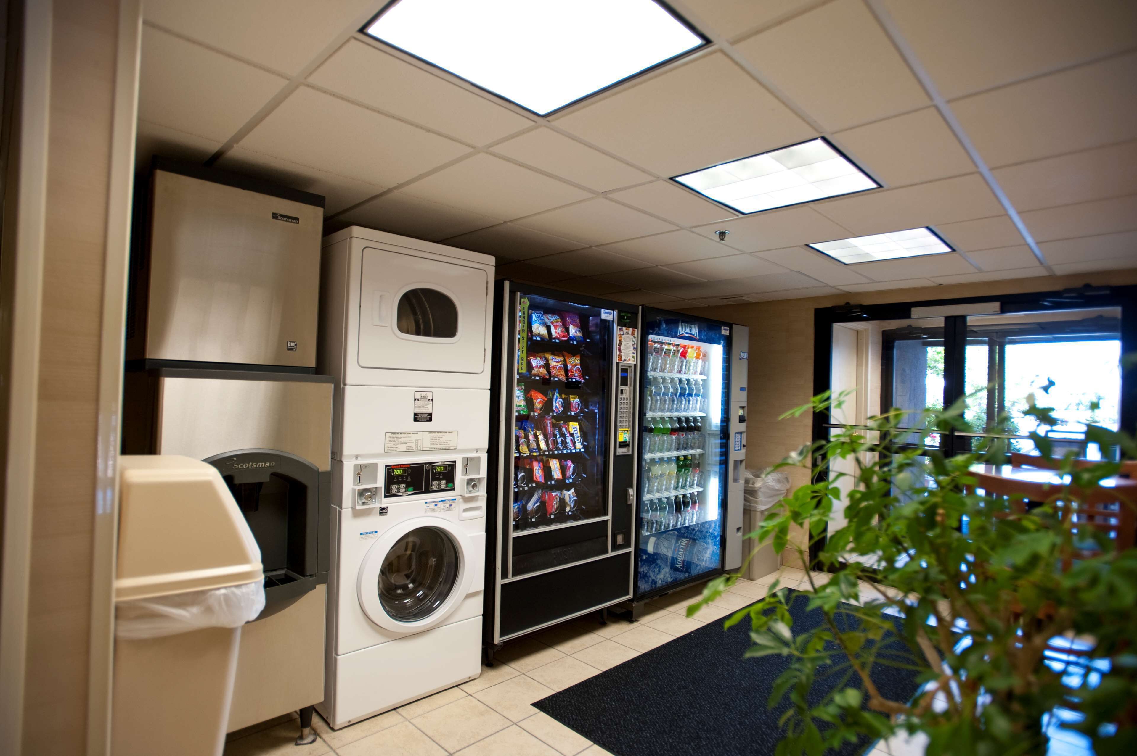A laundry room with a washing machine, a dryer, and vending machines.