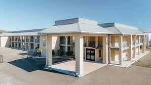 A motel with a central courtyard, multiple balconies, and a covered entrance.