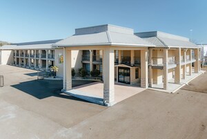 Un motel con patio central, varios balcones y entrada cubierta.