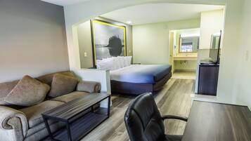 Ein modernes Hotelzimmer mit einer Couch, einem Bett, einem Schreibtisch und einem Sessel.