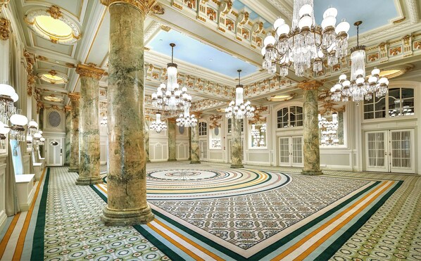 A grand hall with ornate chandeliers, marble columns, and a patterned floor. - Willard InterContinental Washington by IHG (Washington)
