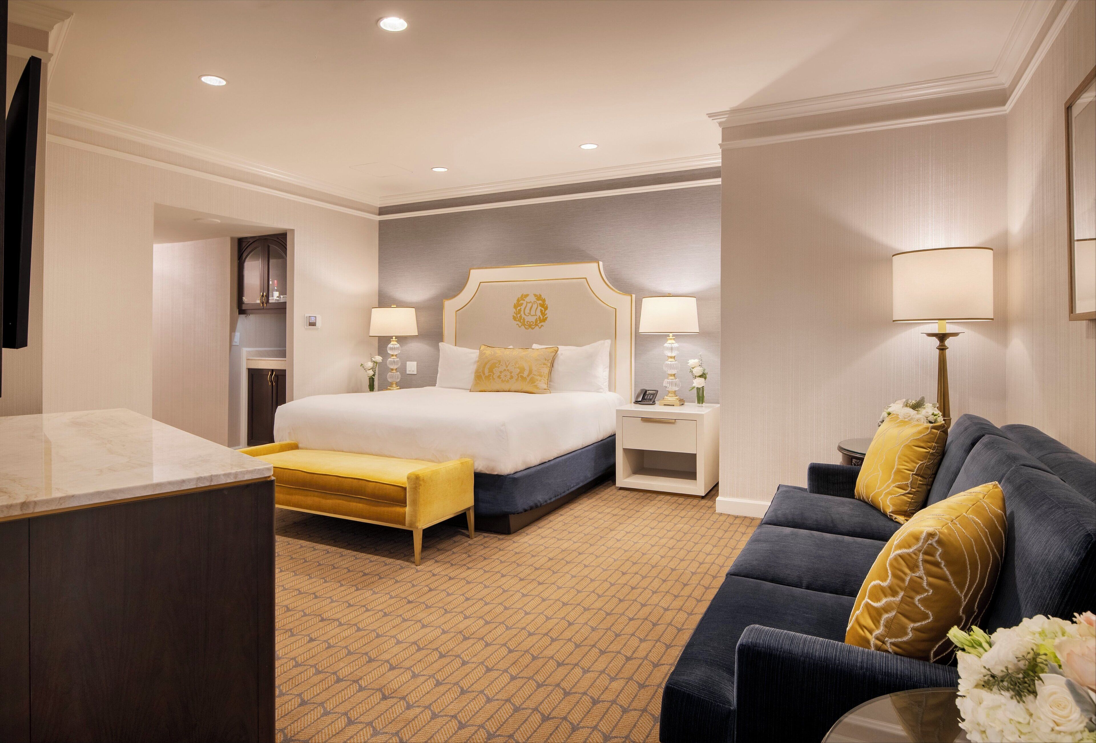 Ein Hotelzimmer mit einem Bett, einer Couch, einem Nachttisch und einem Schreibtisch.