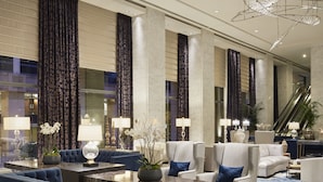 A spacious lobby with a blue sofa, armchairs, and a patterned carpet. - Hotel Nikko San Francisco (San Francisco)