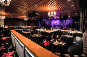 A restaurant with a bar area, booths, and a stage with a sign.
