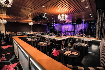 A conference room with round tables and chairs, a large screen, and a patterned carpet. at Hotel Nikko San Francisco