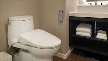 A modern bathroom with a toilet, a sink, and a towel rack.