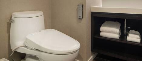 Un baño moderno con inodoro, lavamanos y barra para toallas.