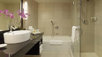 A modern bathroom with a large sink, a bathtub, and a glass-enclosed shower.