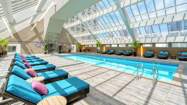 An indoor swimming pool with multiple lounge chairs and a high ceiling with skylights. - Hotel Nikko San Francisco (San Francisco)