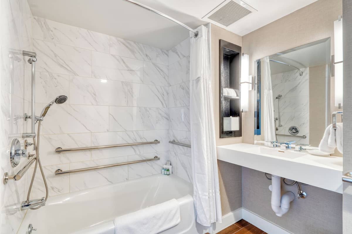 deluxe room, 1 queen bed, accessible | bathroom | designer toiletries, hair dryer, slippers, towels