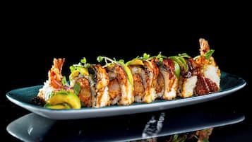 Un plato de sushi con diferentes variedades de sushi sobre un plato oscuro.
