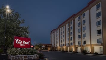 Un hotel Red Roof Inn con un amplio estacionamiento y un letrero.