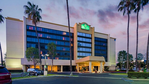 Un hotel con fachada moderna, varios pisos y un letrero llamativo.