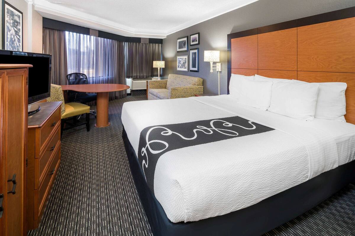 Una habitación de hotel con una cama grande, un escritorio, un televisor y una silla.