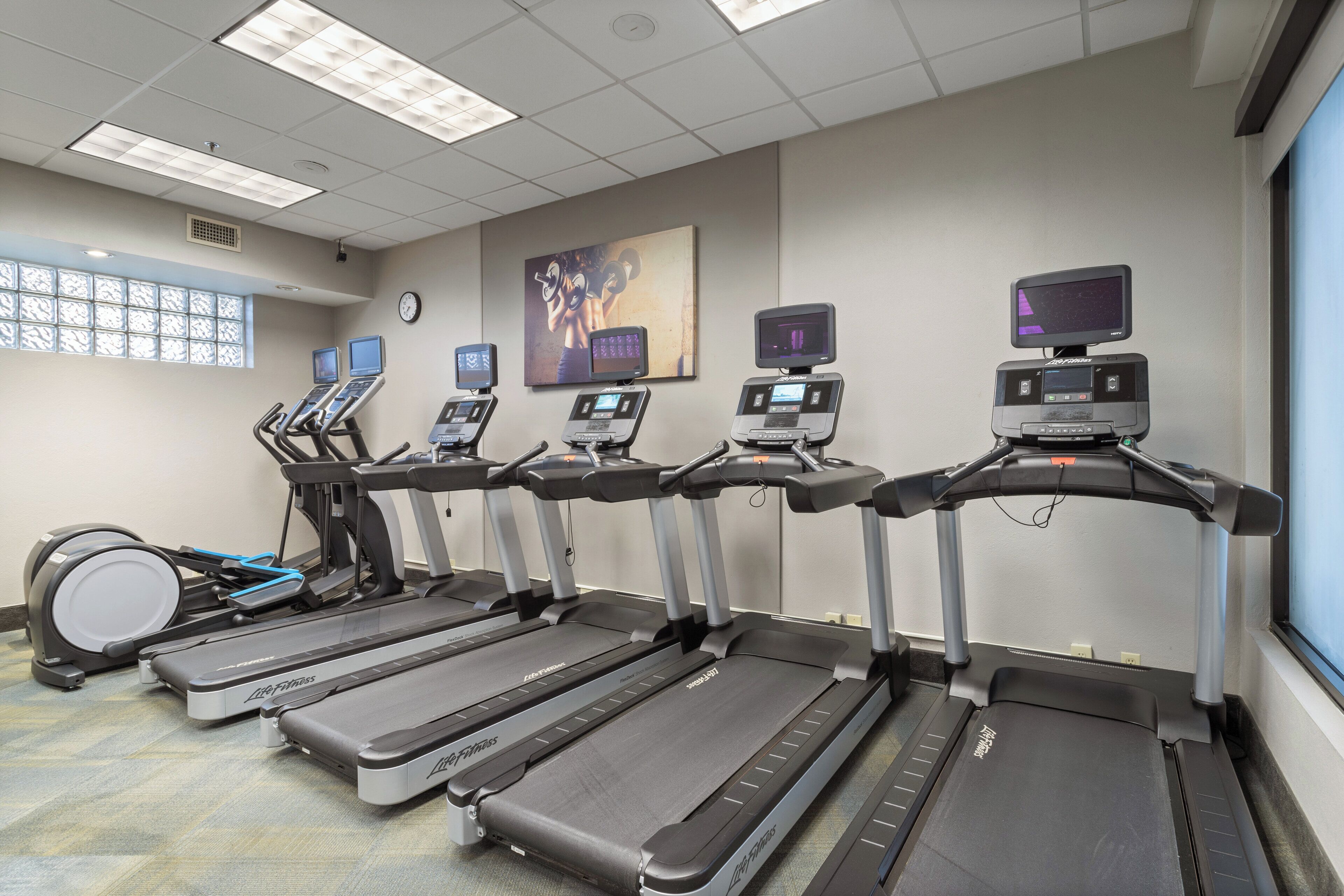 A fitness room with treadmills, ellipticals, and a stationary bike.