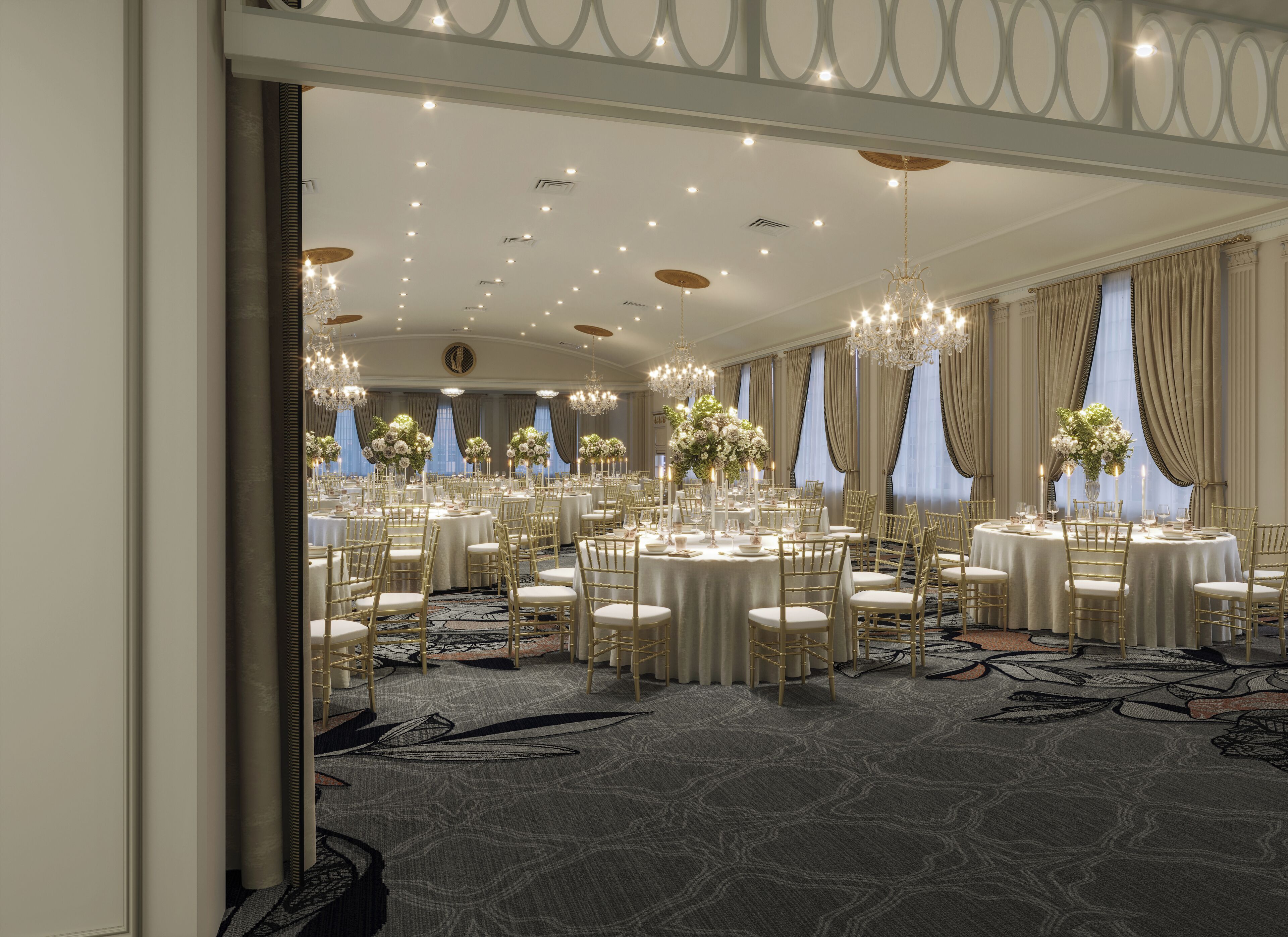 Un amplio salón de banquetes elegantemente decorado con mesas redondas, sillas doradas y candelabros.