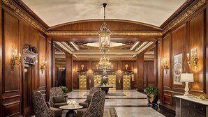 A luxurious lobby with ornate wood paneling, a grand chandelier, and elegant seating arrangements. - Omni Parker House  (Boston)