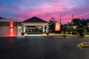 Een Red Roof Inn & Suites met een overdekte ingang en een neonbord.