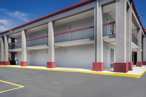 A multi-level building with a covered entrance and a yellow safety line on the pavement.