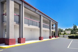 Estacionamento com vários andares, galeria coberta e céu azul.