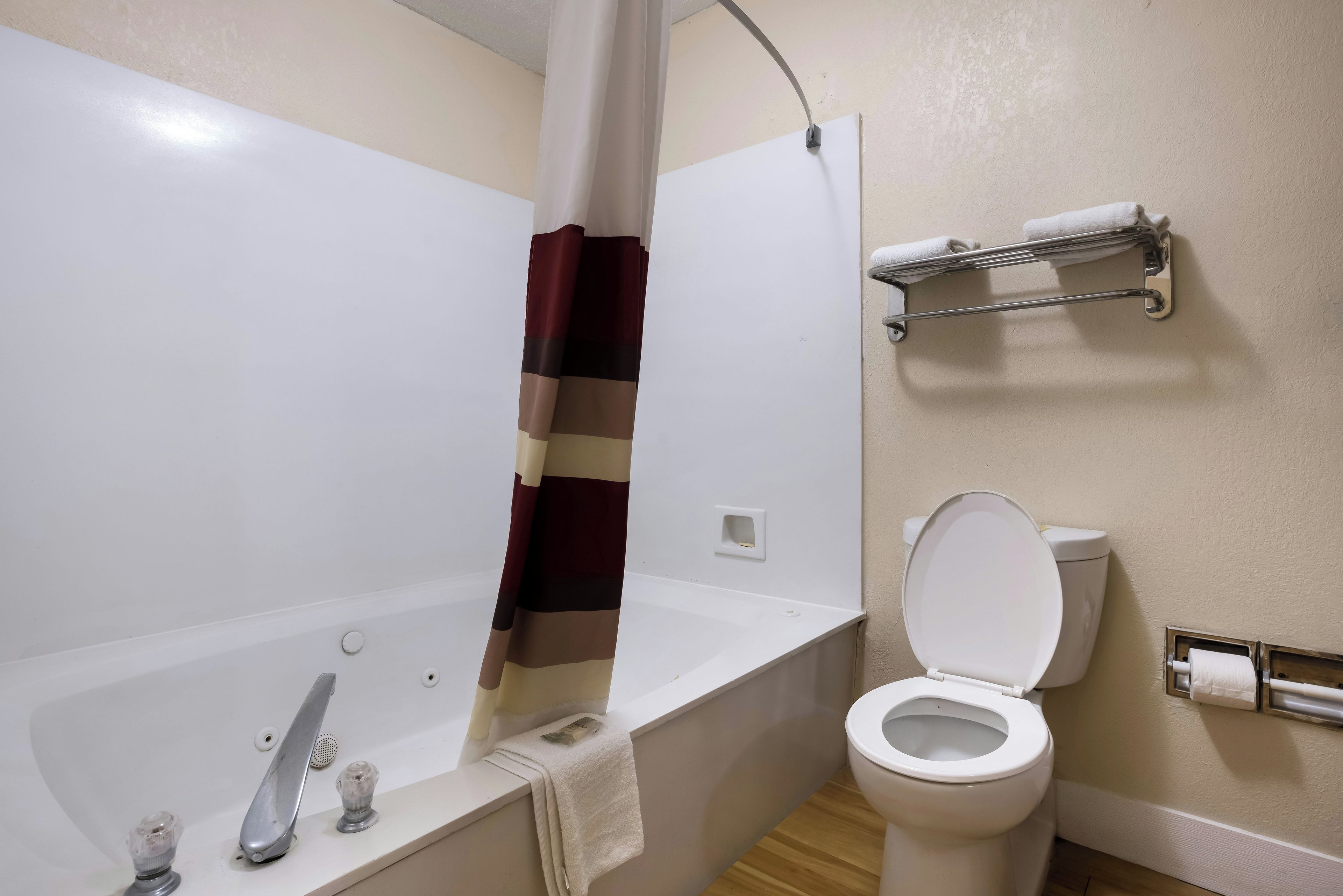 Un bagno con vasca, WC e portasciugamani.