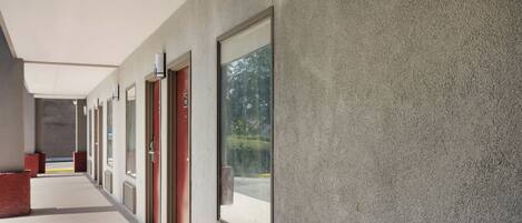 A corridor with doors, windows, and a ceiling.