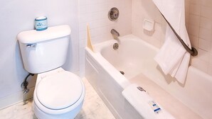 A bathroom with a toilet, bathtub, and shower curtain.