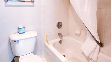 A bathroom with a toilet, bathtub, and shower curtain.