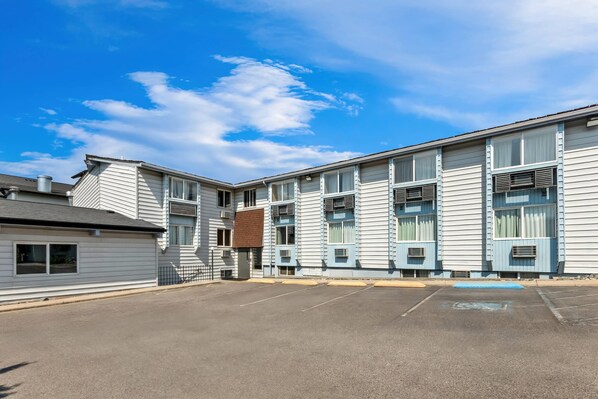 A multi-story building with a parking lot in front.